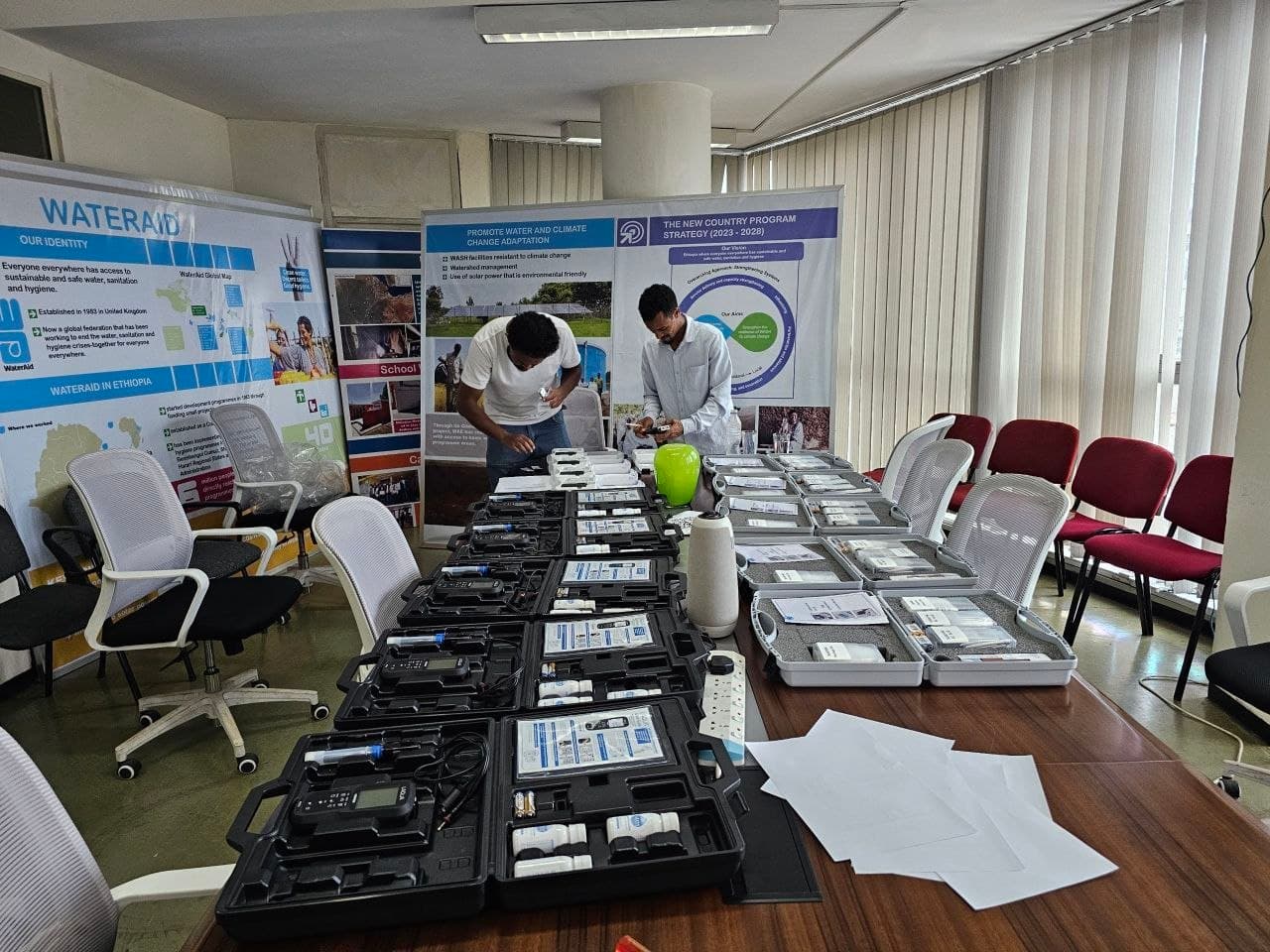 Ethiolab technicians checking portable water-testing kits laid out for hand-over